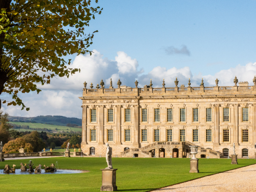 Exterior of a large mansion house with a well kept lawn