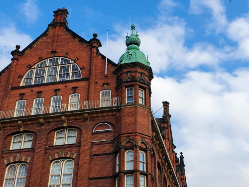 A close-up for the top of the Newcastle Discovery Museum building under a blue sky with white clouds