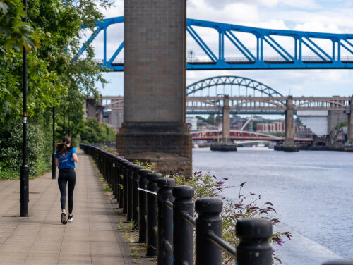 The back of a woman running beside the River Tyne in Newcastle