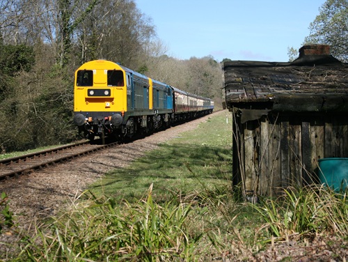 Northern train on tracks passing a small wooden shed